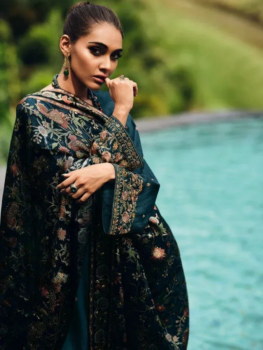 Woman in dark floral embroidered ethnic gown by pool, Indian designer wear