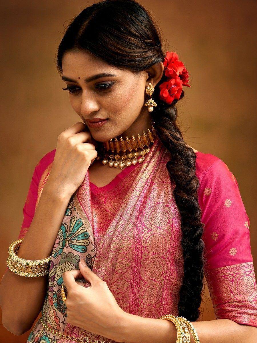 Woman in pink designer saree with gold jewelry and red flowers, ethnic Indian wear