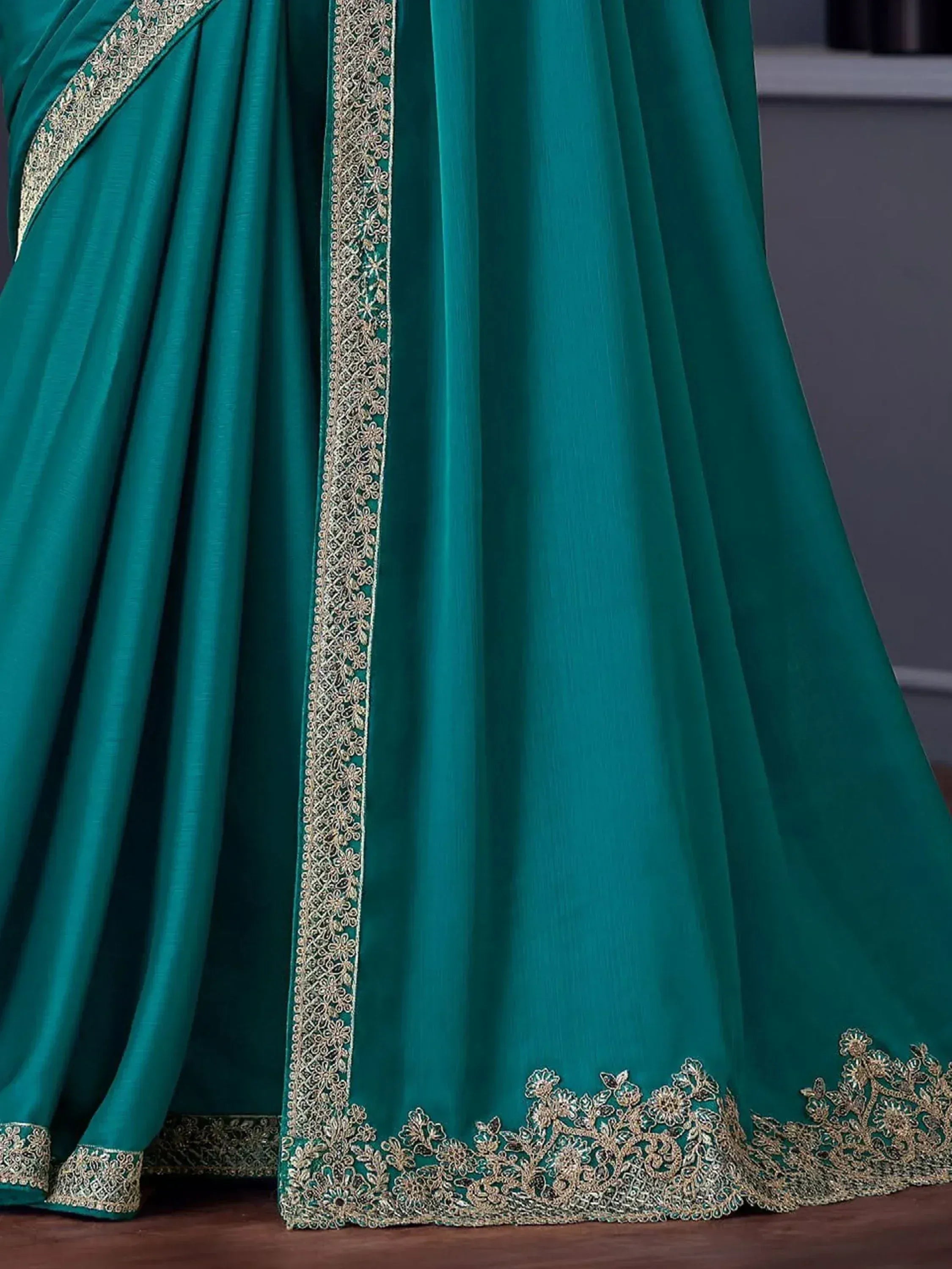 Emerald green saree with gold floral embroidery, perfect for Indian ethnic wear occasions.