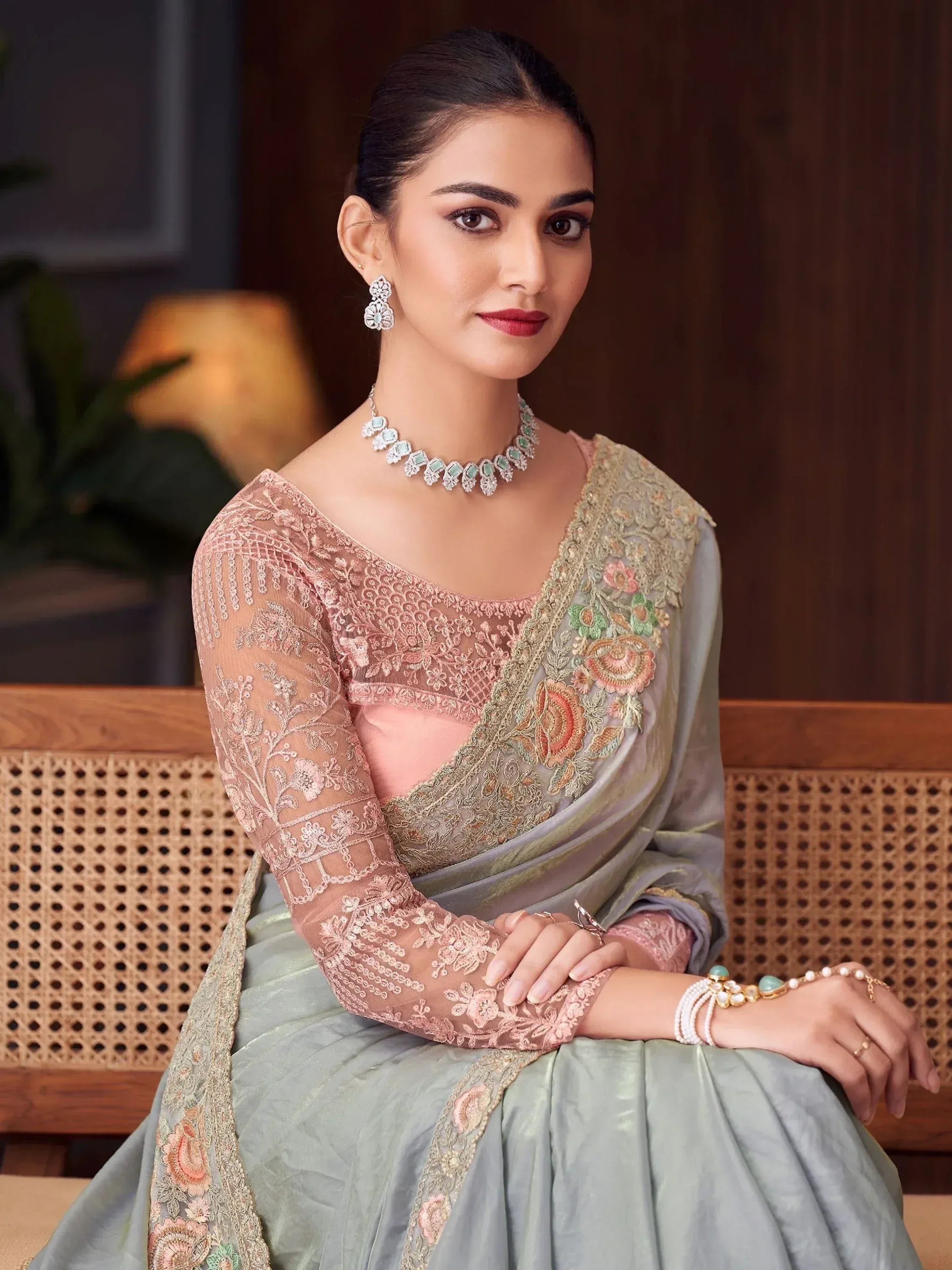 Elegant woman in designer lehenga choli with floral embroidery, paired with statement jewelry for Indian ethnic wear.