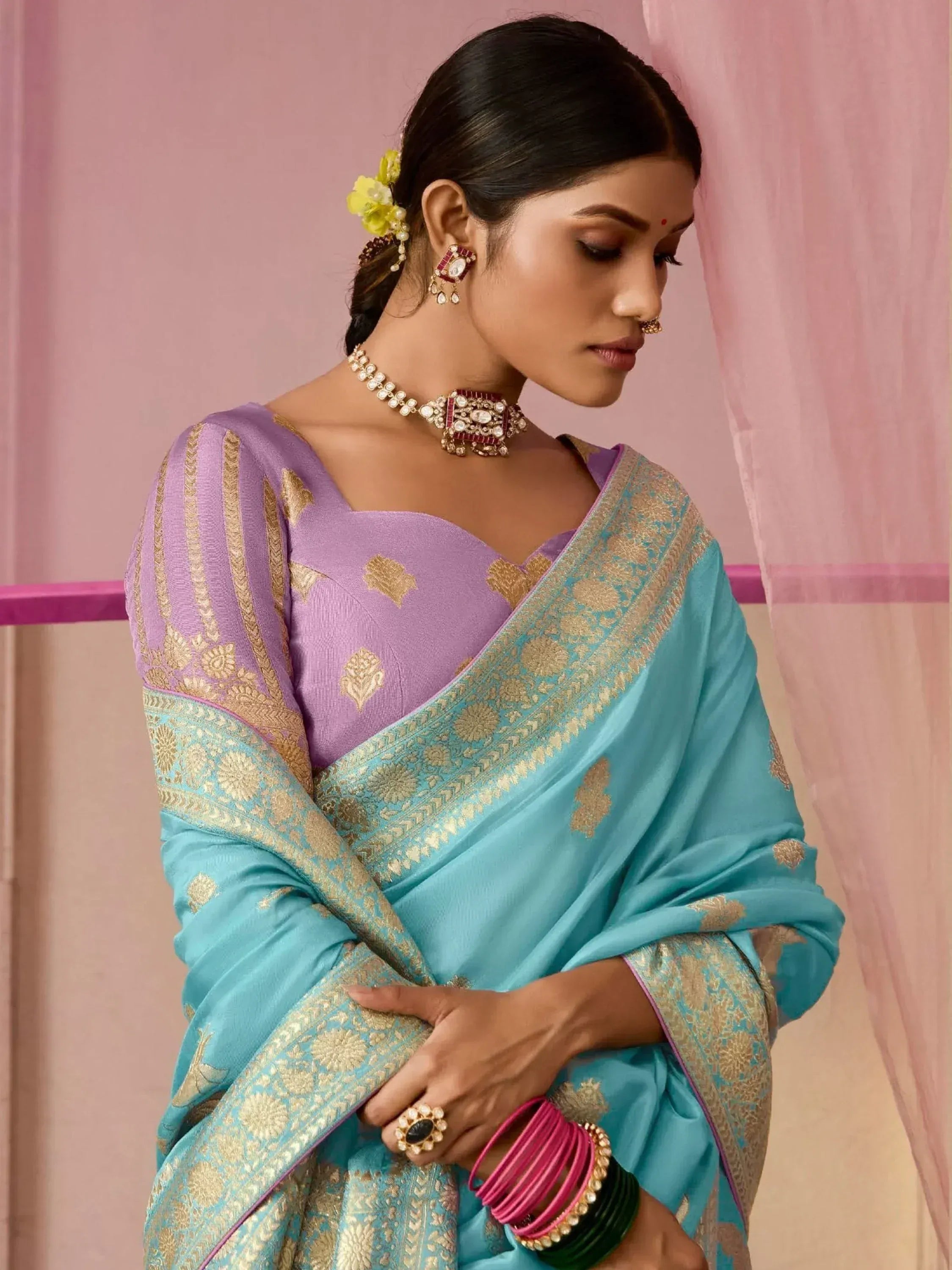 Woman in purple and turquoise designer saree with gold embroidery, traditional Indian ethnic wear