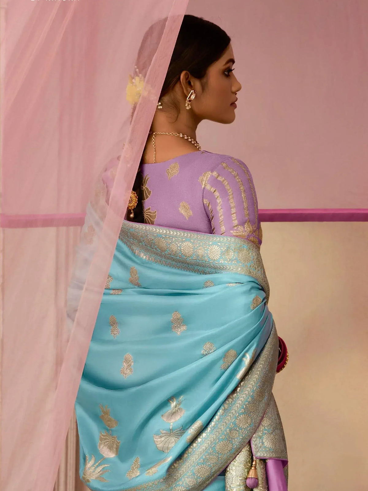 Woman in blue and purple designer saree with gold embroidery, ethnic Indian wear