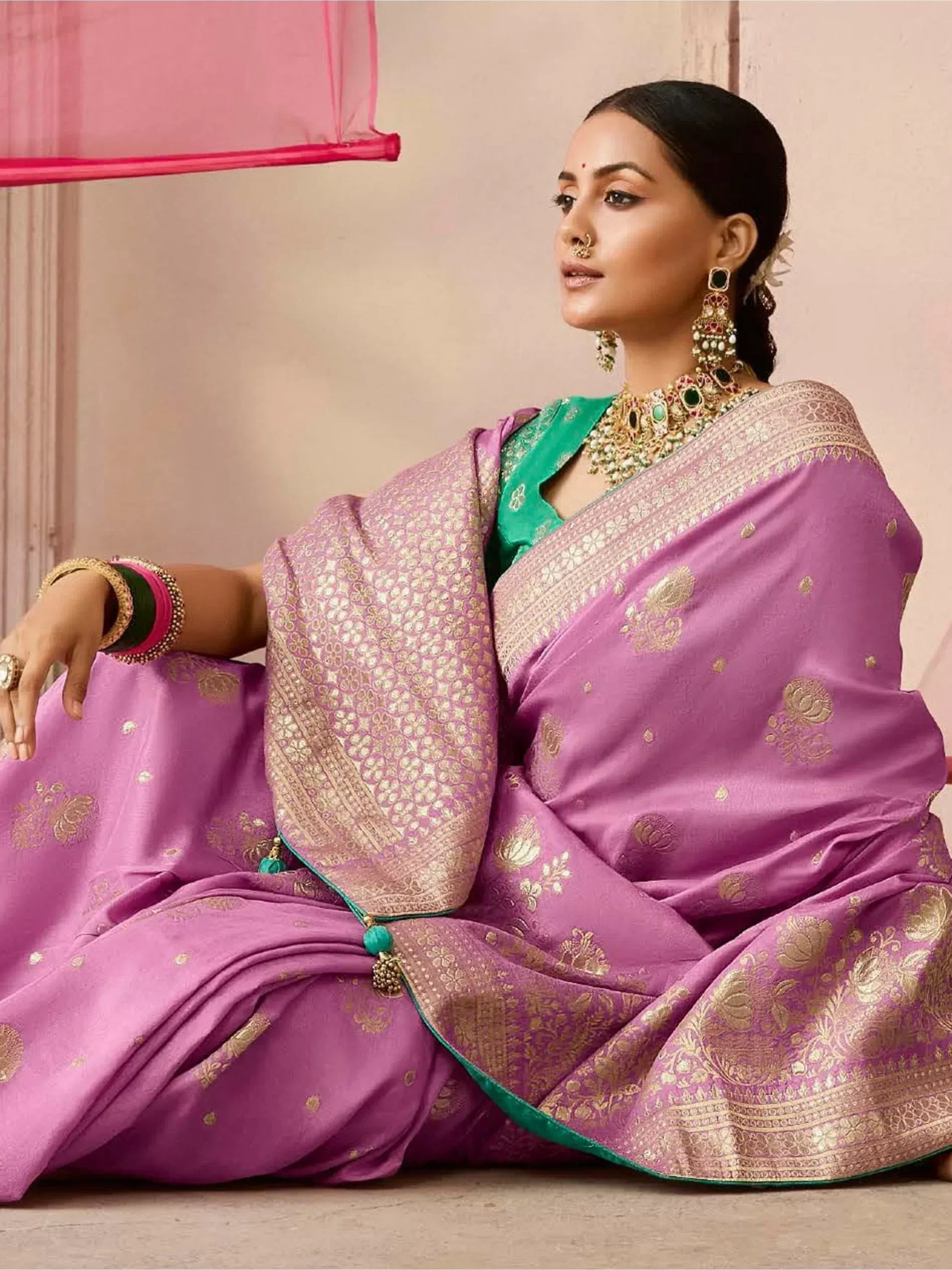 Elegant purple saree with gold embroidery and green blouse, styled with traditional Indian jewelry for festive occasions.