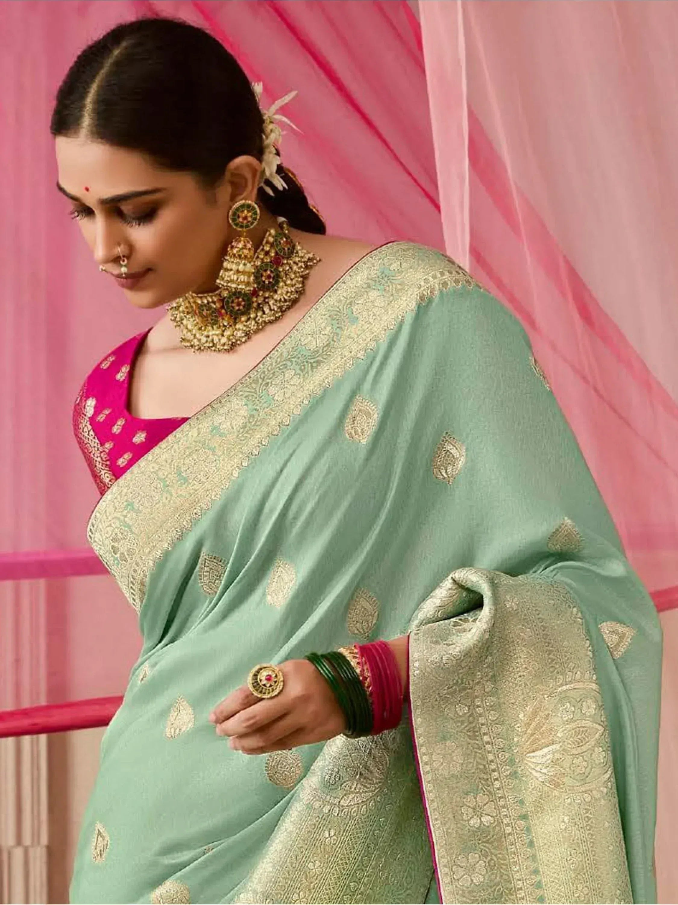 Mint green saree with gold embroidery and pink blouse, styled with traditional Indian jewelry for ethnic wear