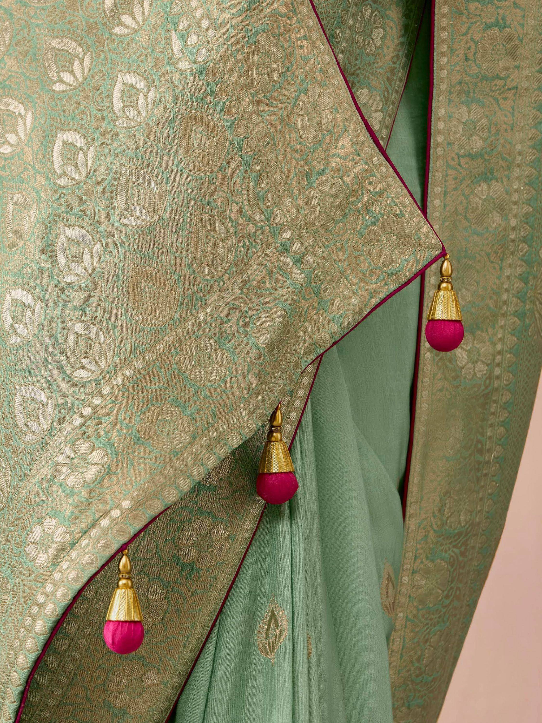 Mint green designer saree with gold floral weave and pink tassels, ethnic Indian wear