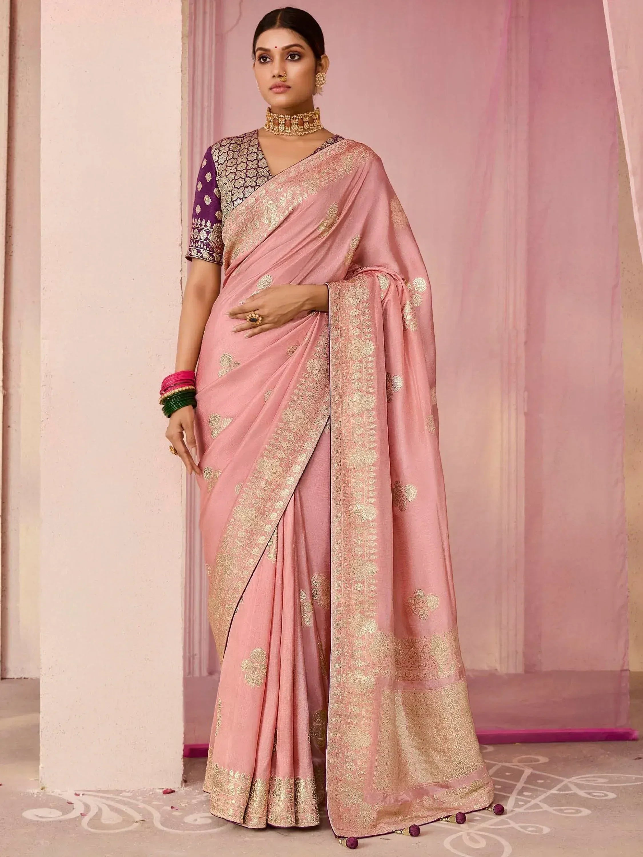 Pink saree with gold embroidery, purple blouse, and traditional jewelry for Indian ethnic wear