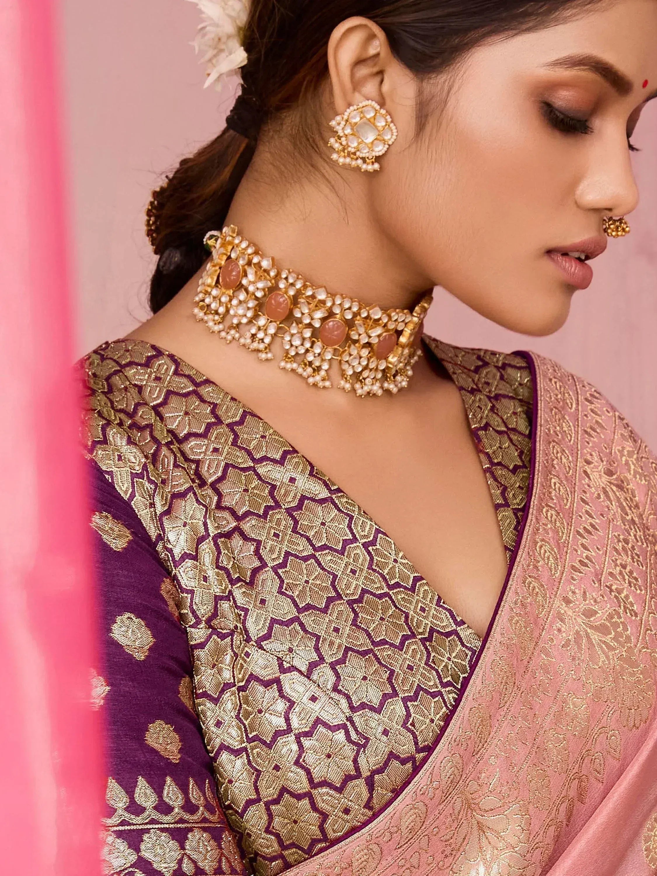Woman in purple and gold embroidered saree with pearl and stone jewelry, traditional Indian ethnic wear