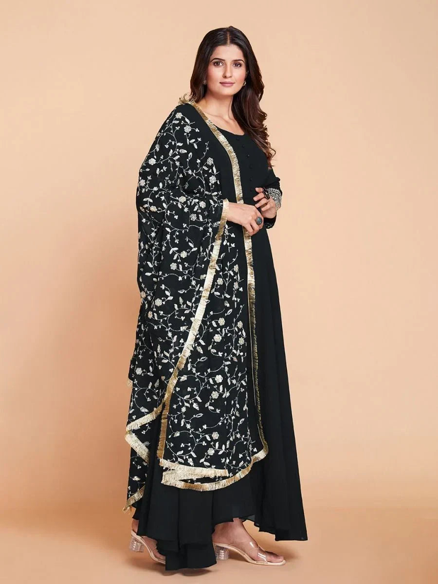 Woman wearing black embroidered salwar kameez with floral dupatta and gold trim