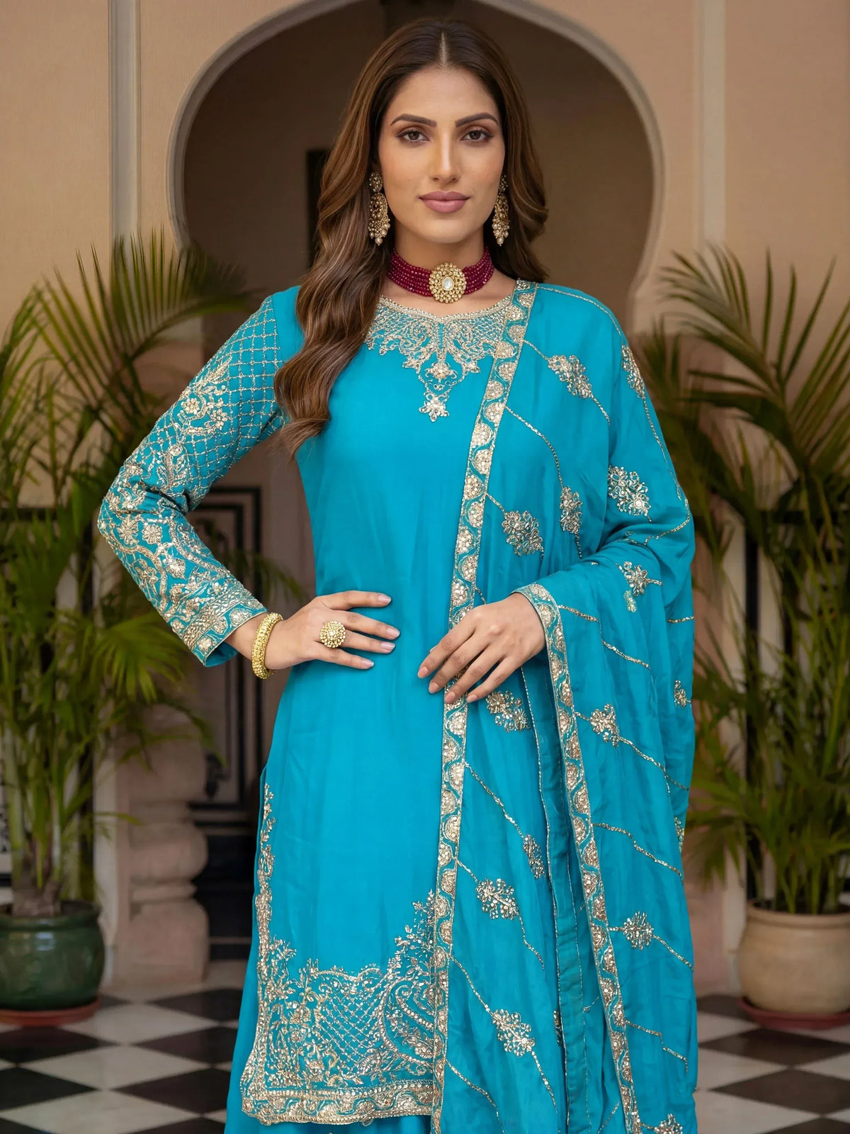 Turquoise designer salwar kameez with gold embroidery, perfect for Indian ethnic wear occasions.