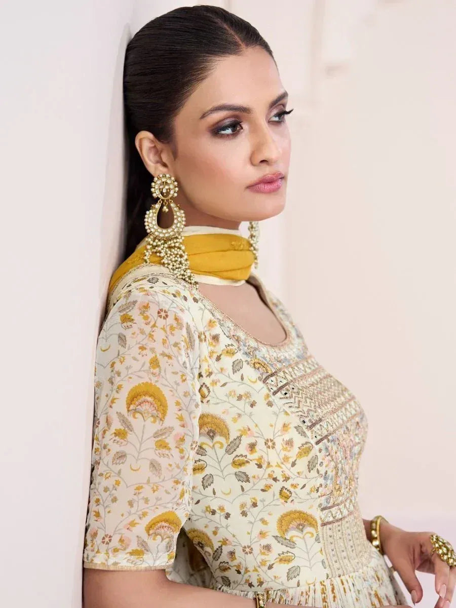 Elegant floral print ethnic gown with gold embroidery, paired with statement earrings and yellow dupatta