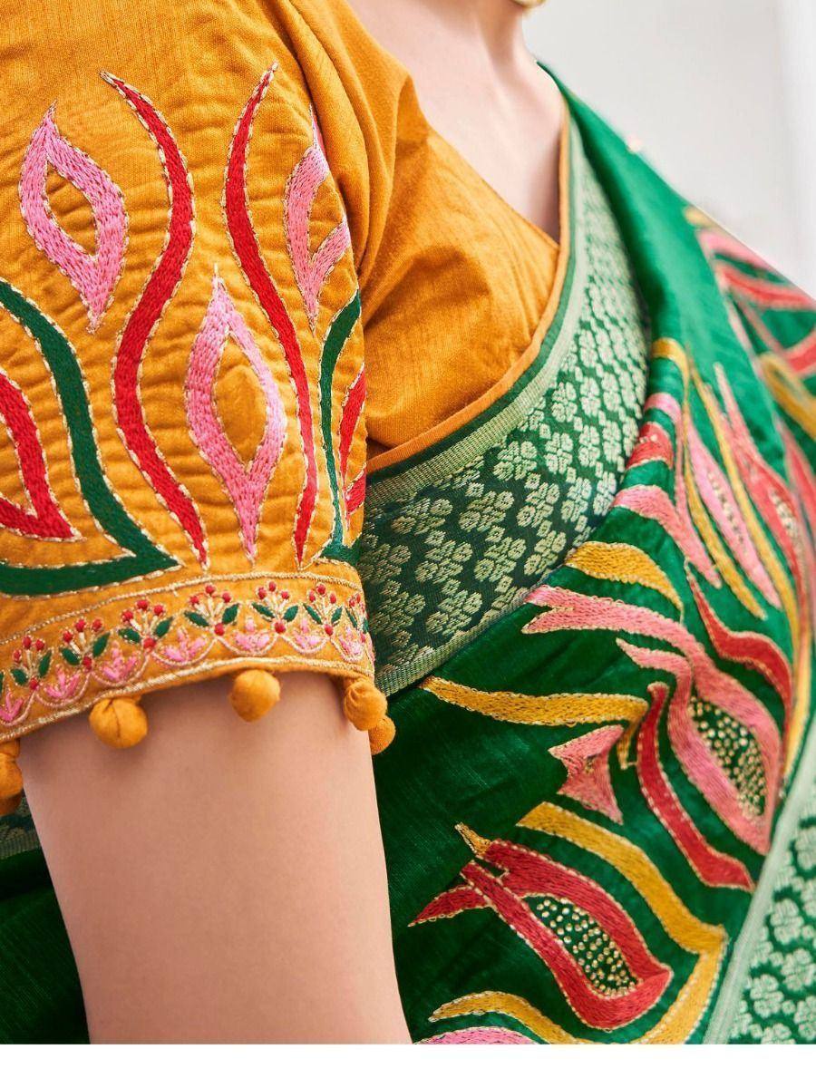Vibrant green and mustard yellow ethnic saree with intricate pink and red embroidery, pom-pom sleeves, perfect for festive occasions.