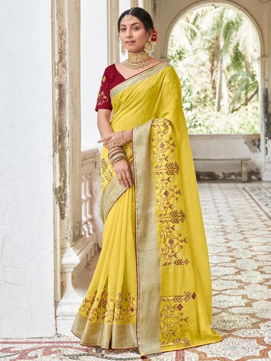 Yellow embroidered saree with gold border, paired with maroon blouse, ideal for Indian ethnic wear
