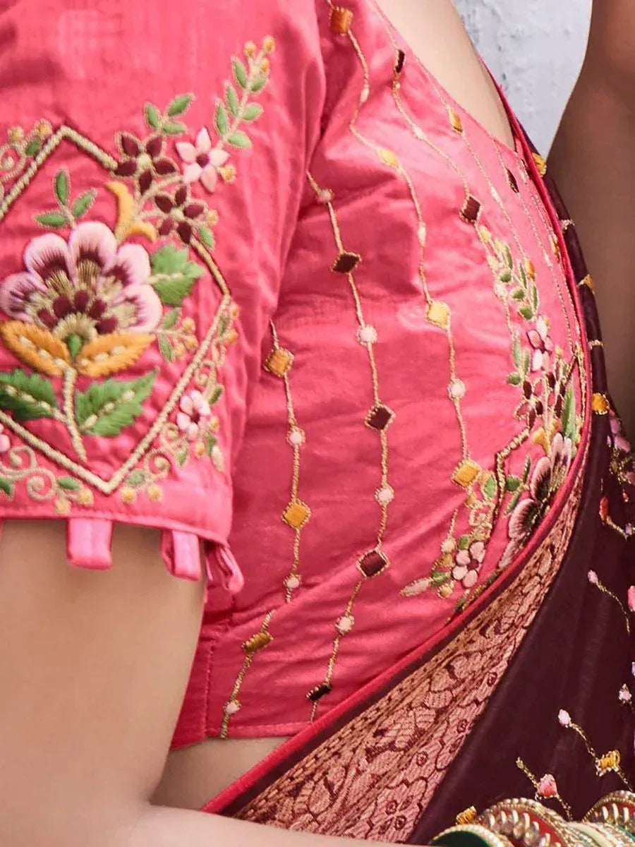 Pink embroidered blouse with floral motifs and gold detailing, paired with maroon saree for ethnic wear