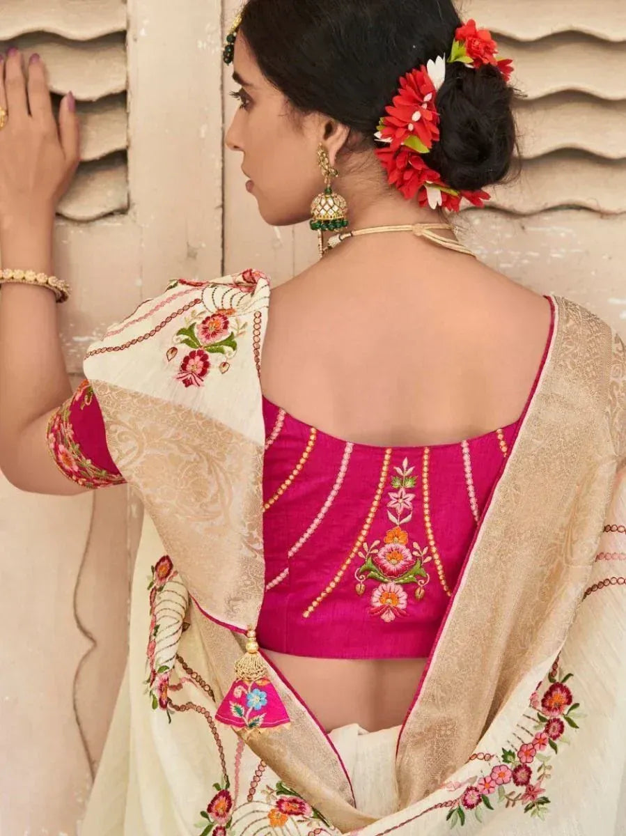 Pink embroidered blouse with floral motifs, paired with cream saree, traditional Indian ethnic wear