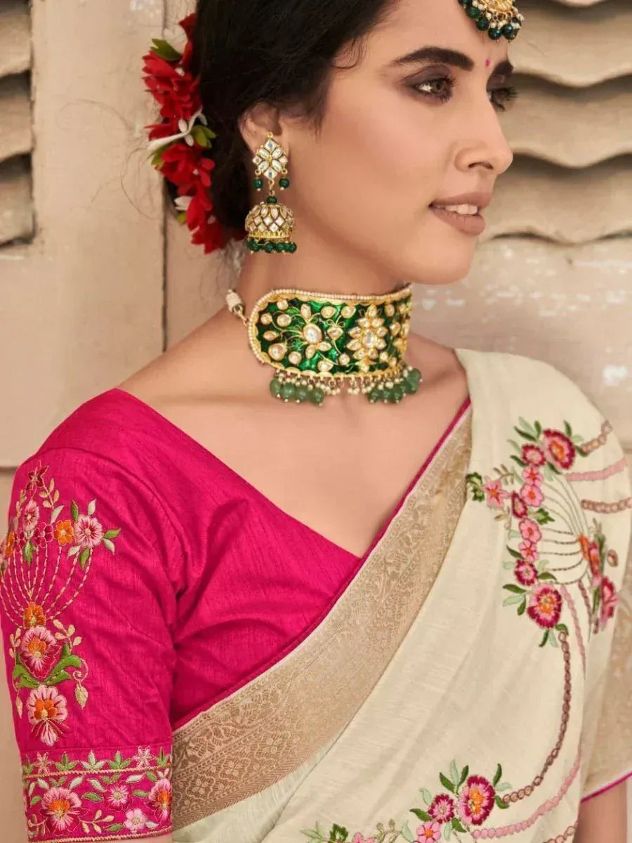 Woman in embroidered pink blouse and floral saree with green gold jewelry, Indian ethnic wear