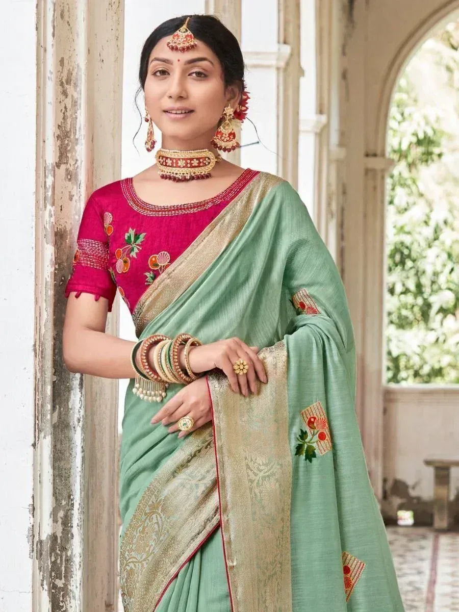 Woman in mint green saree with gold border and pink embroidered blouse, traditional Indian ethnic wear
