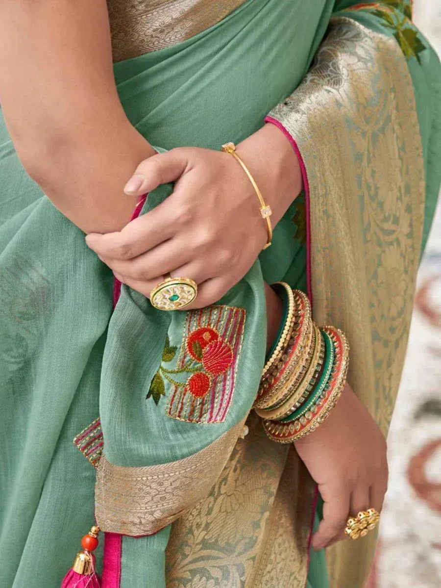 Elegant green saree with gold border, floral embroidery, and traditional bangles for Indian ethnic wear
