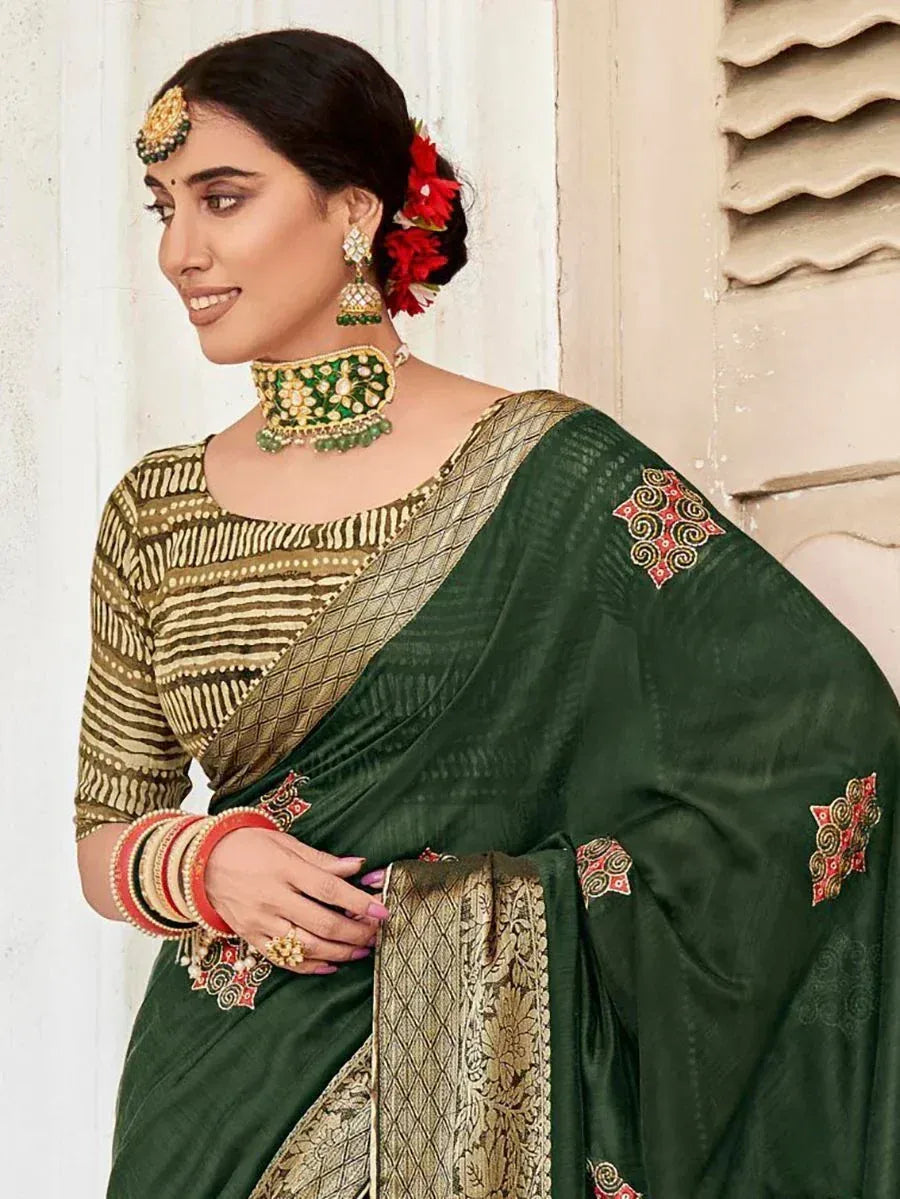 Woman in green embroidered saree with gold blouse, traditional Indian ethnic wear, perfect for festive occasions.