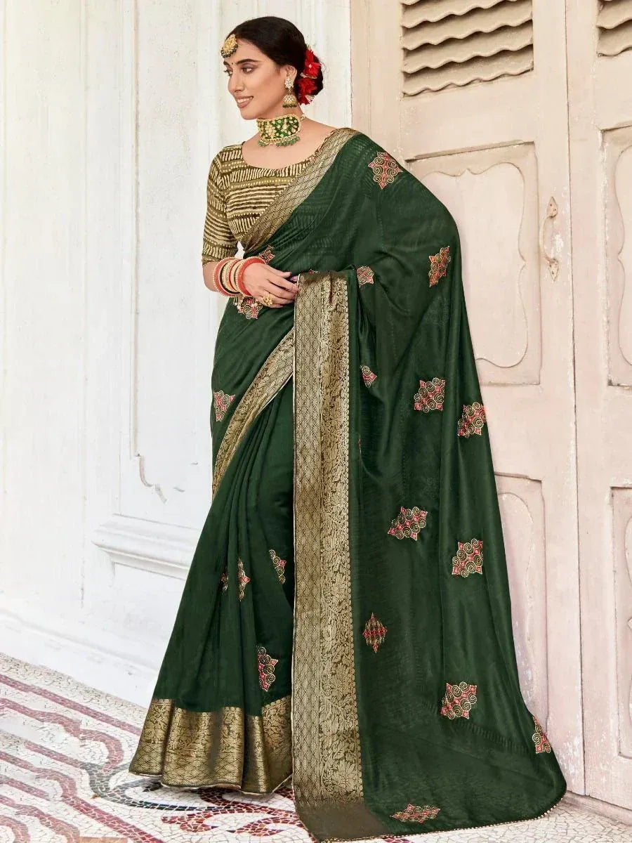 Emerald green embroidered saree with gold border and matching blouse, styled with traditional jewelry for ethnic wear.