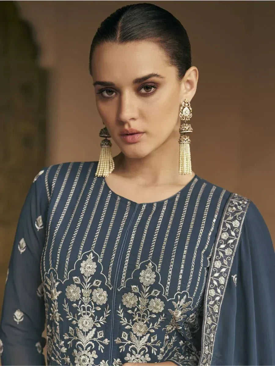 Navy blue embroidered ethnic kurti with floral detailing and gold thread work, paired with statement earrings