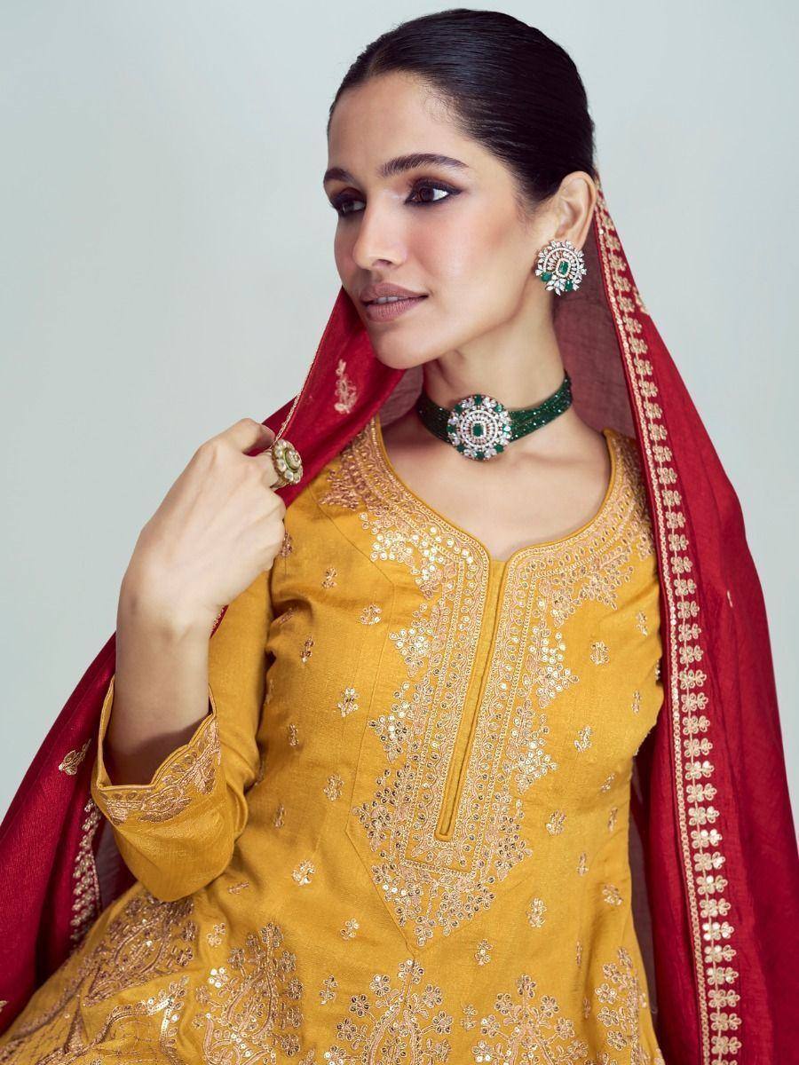 Yellow embroidered ethnic kurta with red dupatta and green jewelry, perfect for Indian festive occasions