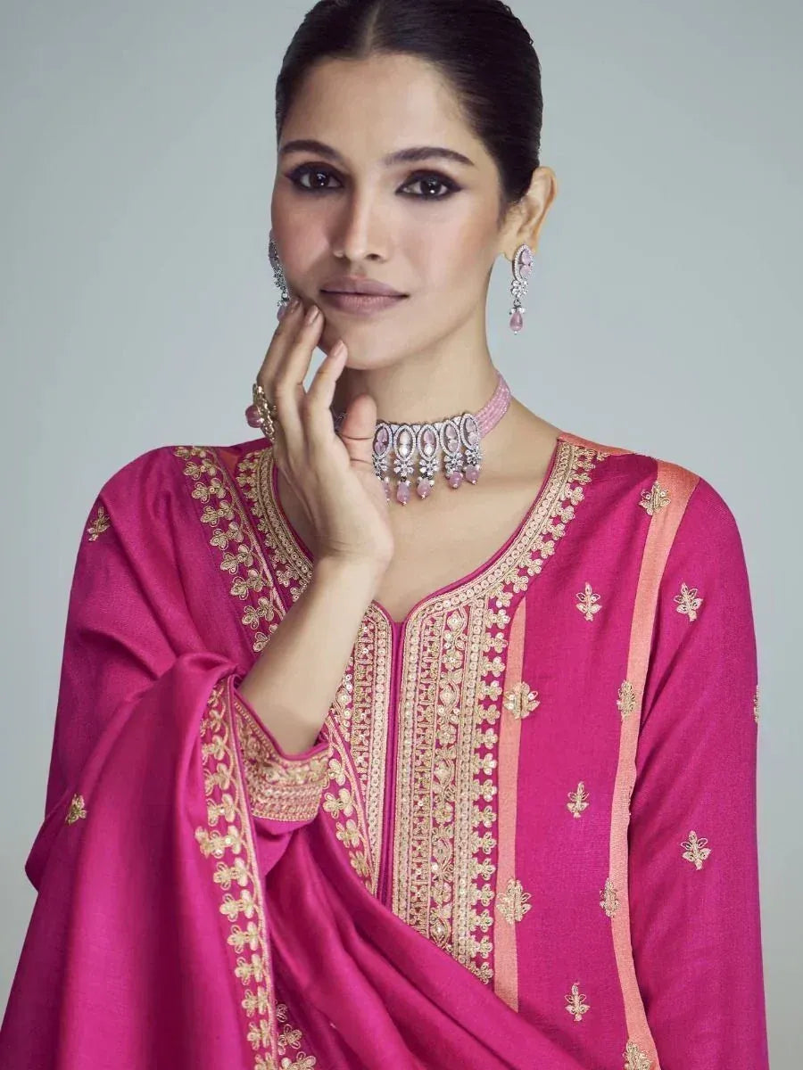 Elegant pink ethnic gown with gold embroidery, paired with statement jewelry for festive occasions