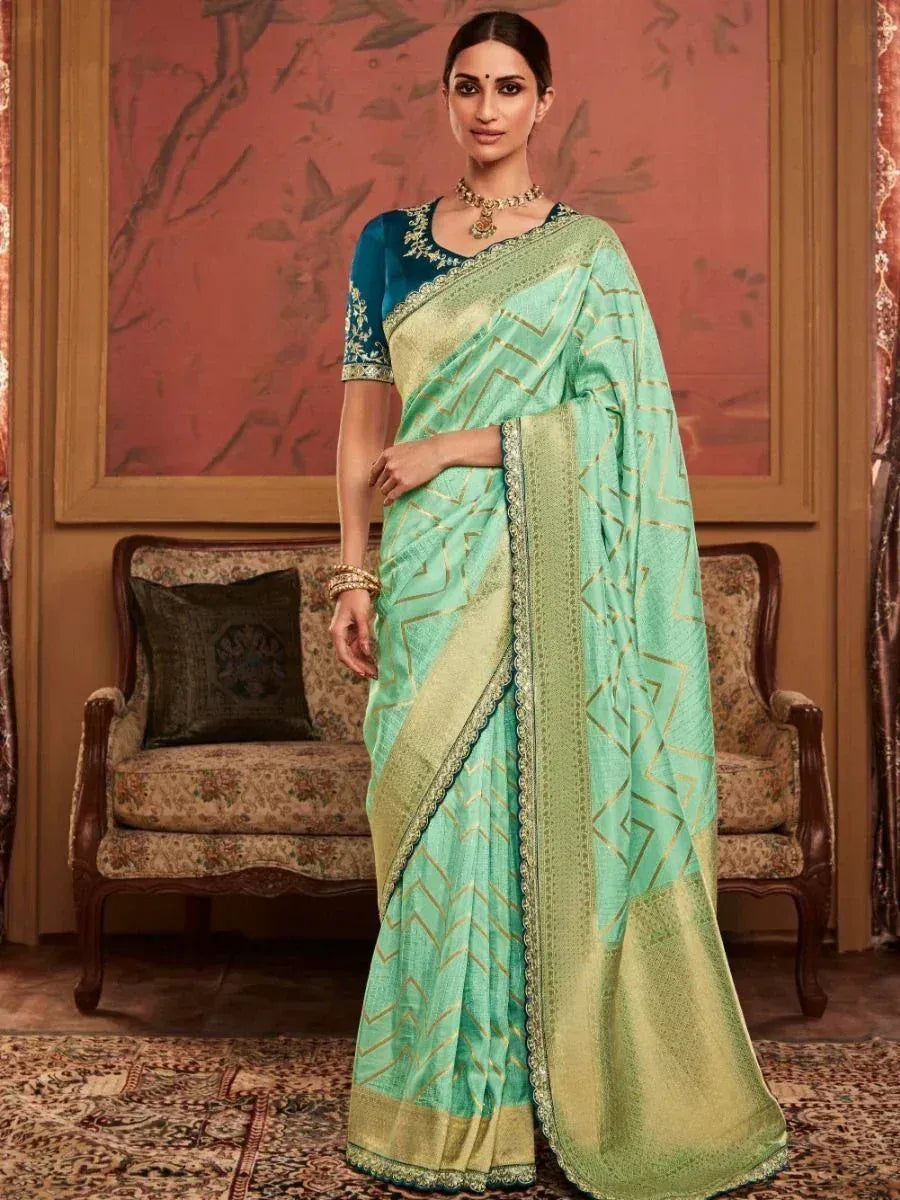 Mint green saree with gold geometric print and embroidered border, paired with teal blouse for ethnic wear