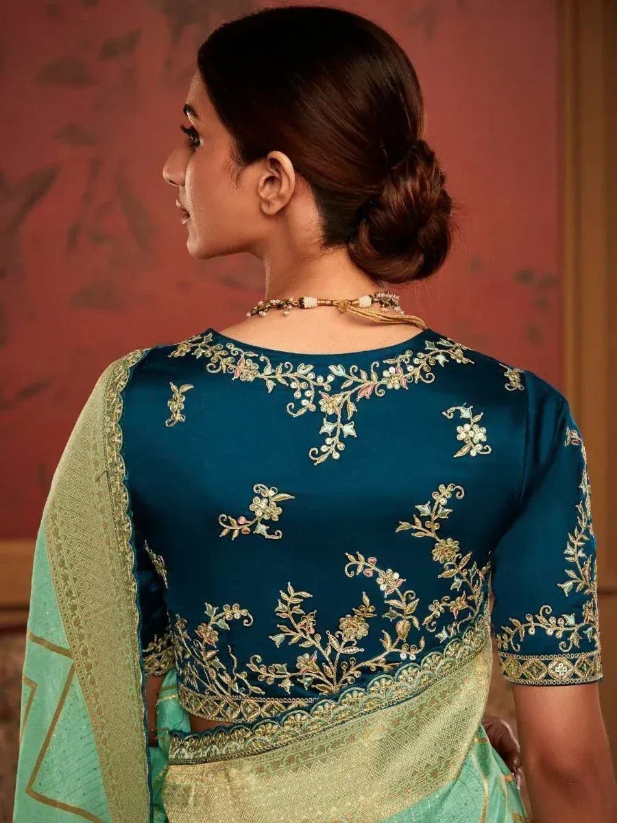 Teal embroidered saree blouse with gold floral detailing, paired with mint green saree for ethnic wear