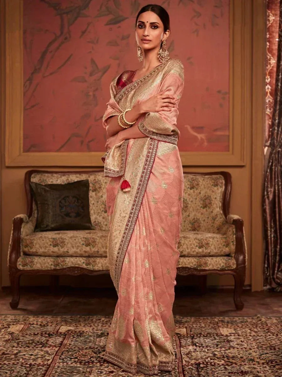 Elegant pink and gold embroidered saree with intricate border, styled for festive occasions