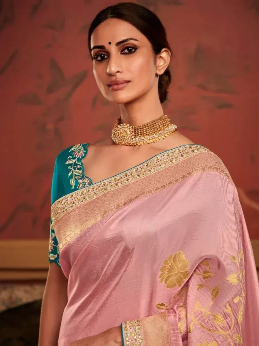 Elegant pink saree with gold floral embroidery and teal blouse, styled with traditional jewelry for Indian ethnic wear.