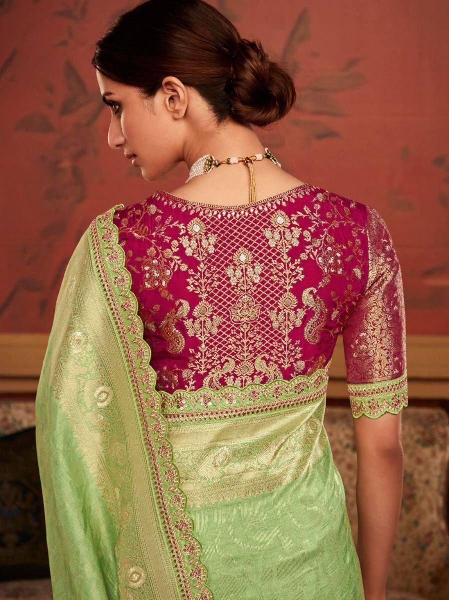 Elegant pink and green saree with intricate gold embroidery and scalloped borders