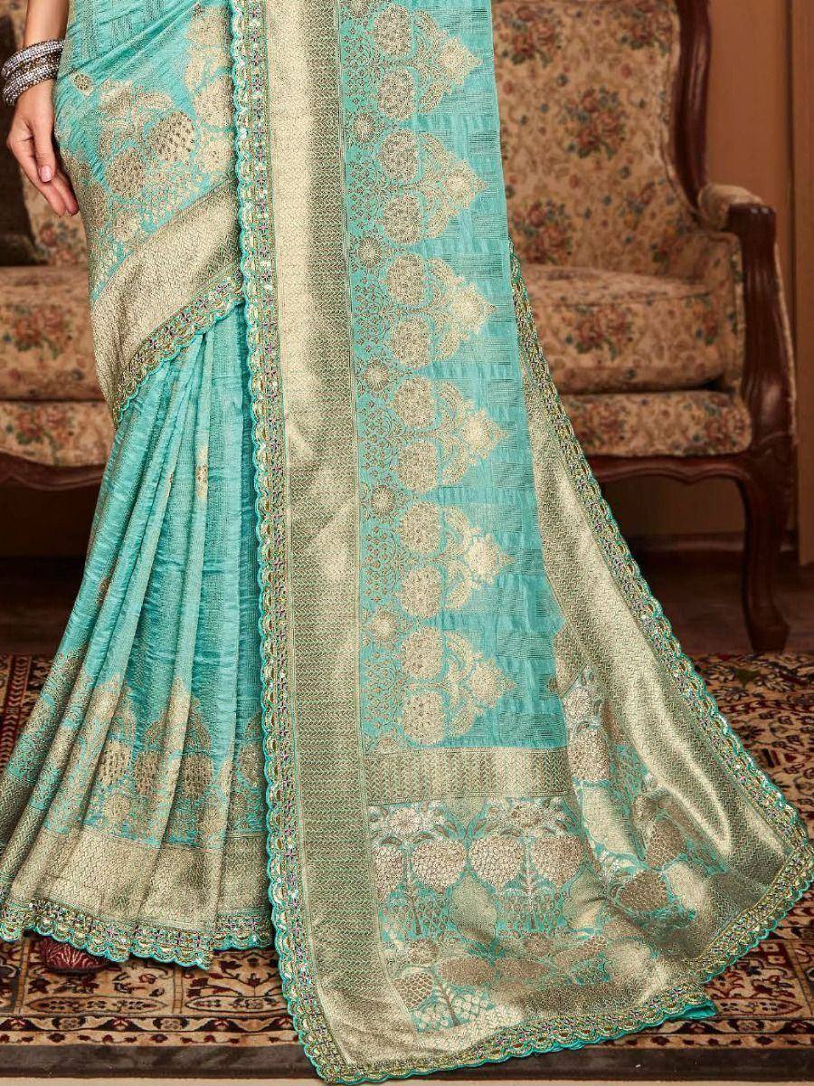Turquoise and gold embroidered saree with intricate floral patterns and scalloped border