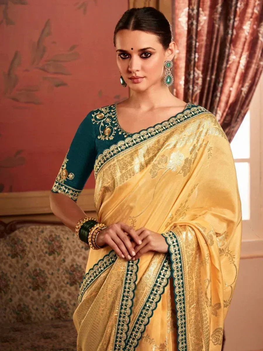 Elegant yellow saree with green blouse, gold embroidery, and scalloped border for Indian ethnic wear