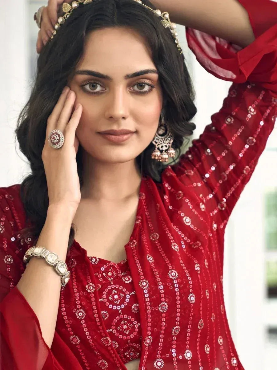 Woman wearing red sequin ethnic lehenga choli with statement jewelry, elegant look