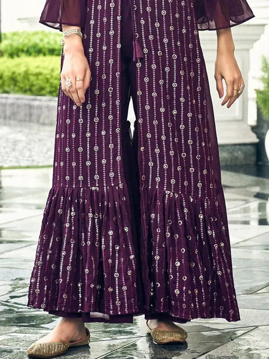 Purple embroidered palazzo pants with sequins, paired with gold ethnic juttis outdoors