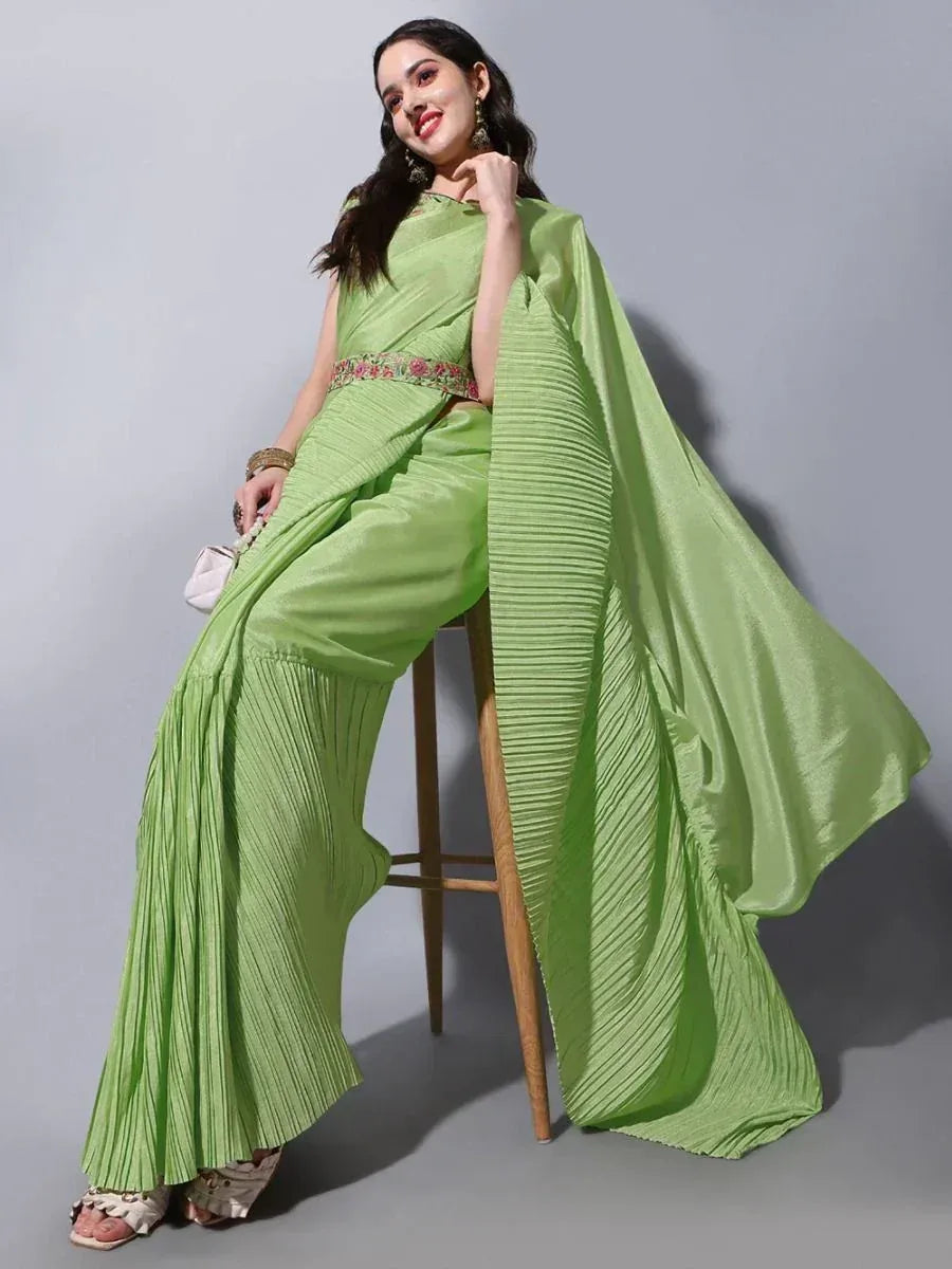 Green pleated ethnic gown with floral waistband, styled for modern Indian wear