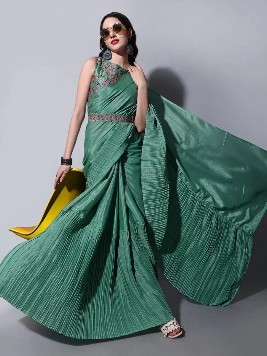 Emerald green pleated saree with floral embroidery, styled with statement earrings and sunglasses for ethnic fashion.