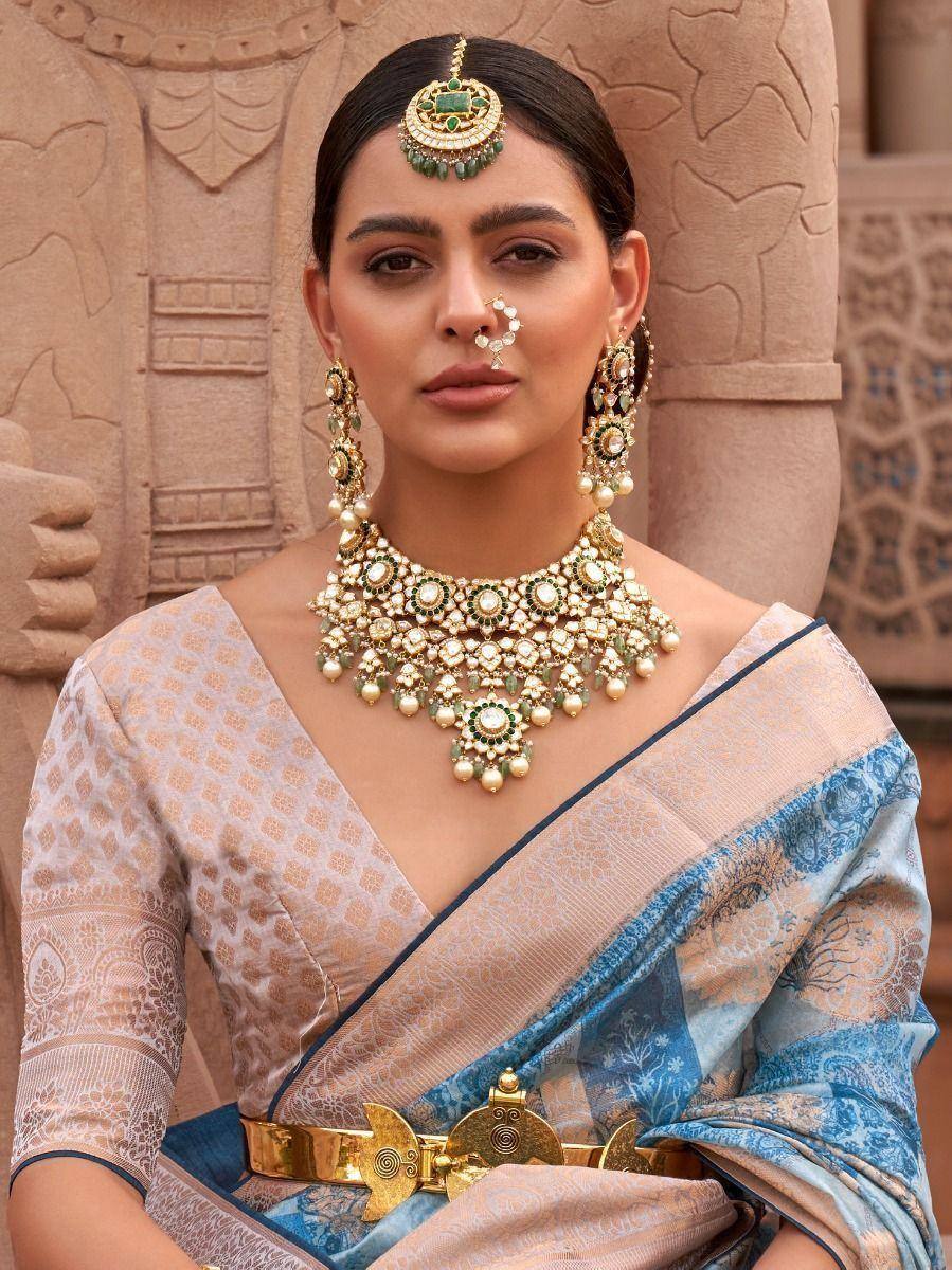 Woman in elegant blue and beige saree with heavy gold jewelry, perfect for Indian ethnic occasions