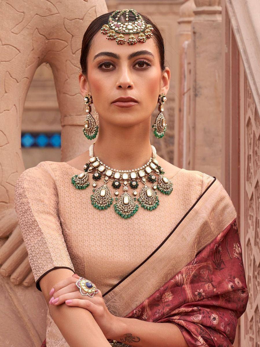 Woman in elegant Indian saree with green and gold jewelry, traditional ethnic wear