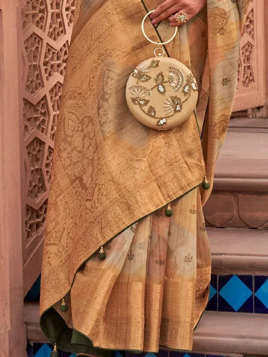 Elegant gold embroidered saree with floral motifs, paired with a matching circular handbag, perfect for Indian ethnic wear occasions.