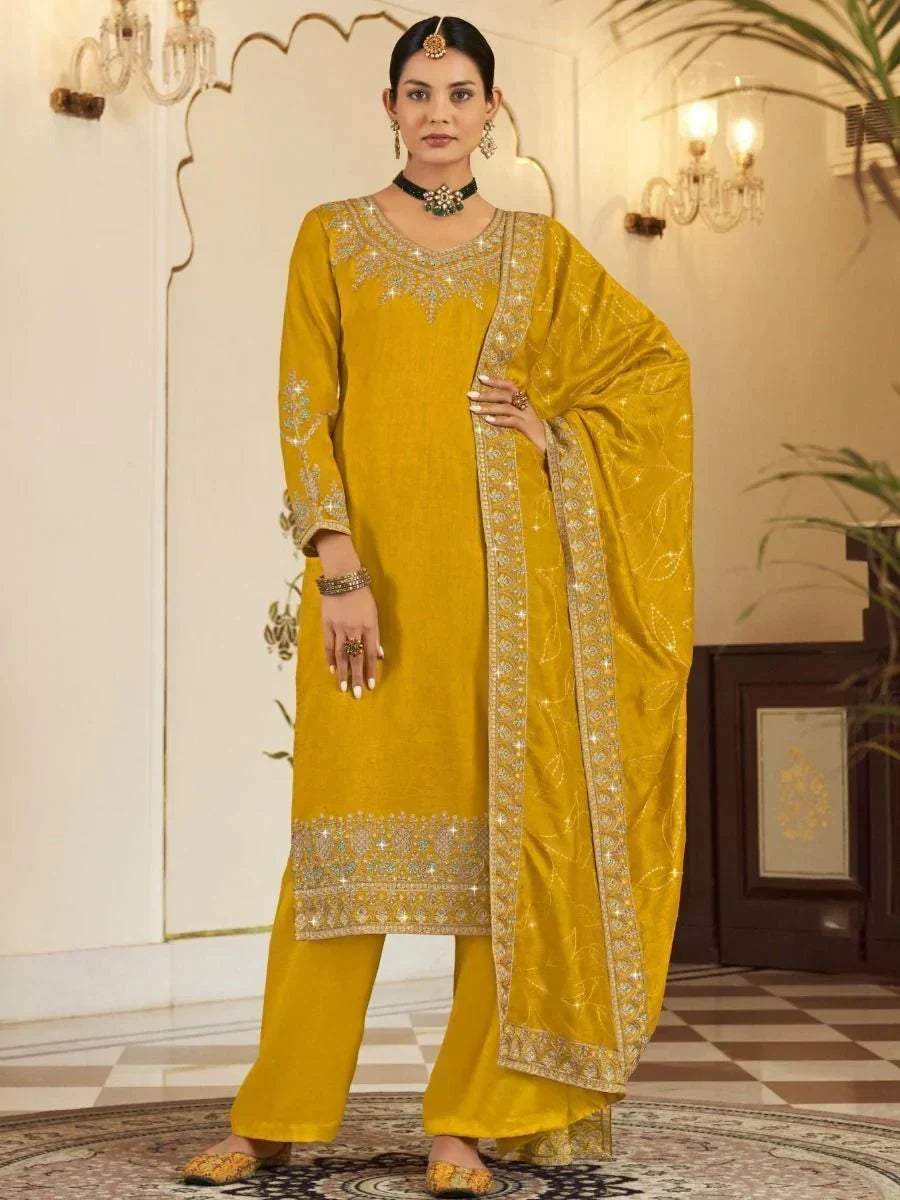 Woman wearing mustard yellow embroidered salwar kameez with matching dupatta in elegant setting
