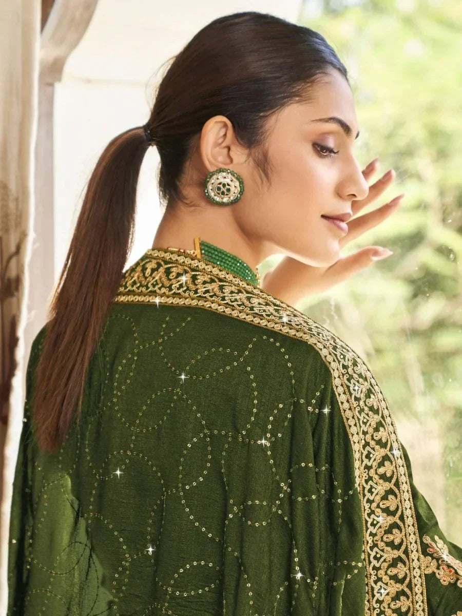 Woman in green embroidered dupatta with gold detailing and traditional earrings