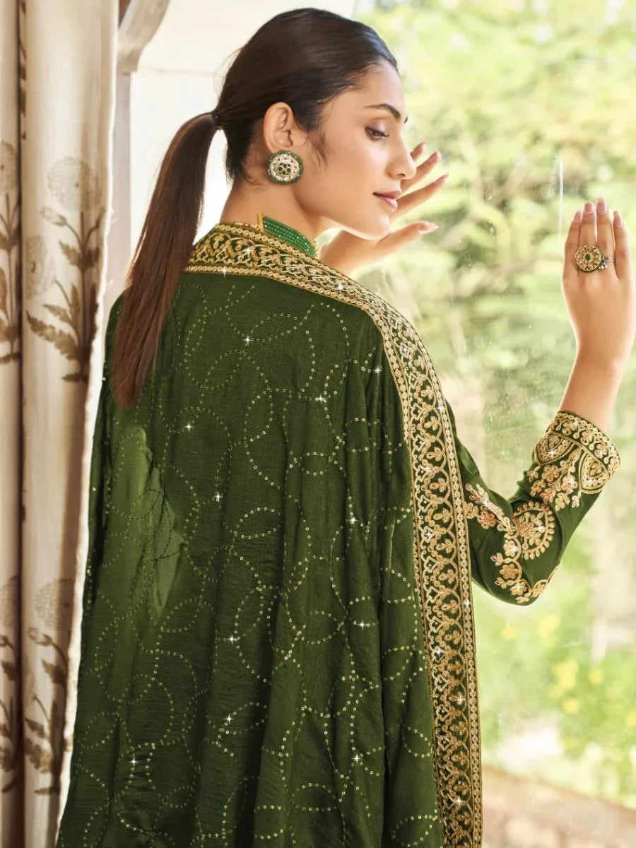 Woman in designer green embroidered ethnic gown with gold details and matching jewelry