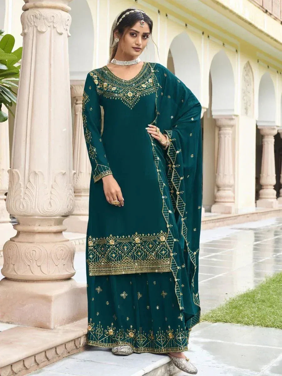 Woman wearing teal embroidered salwar kameez with dupatta, ethnic Indian outfit outdoors