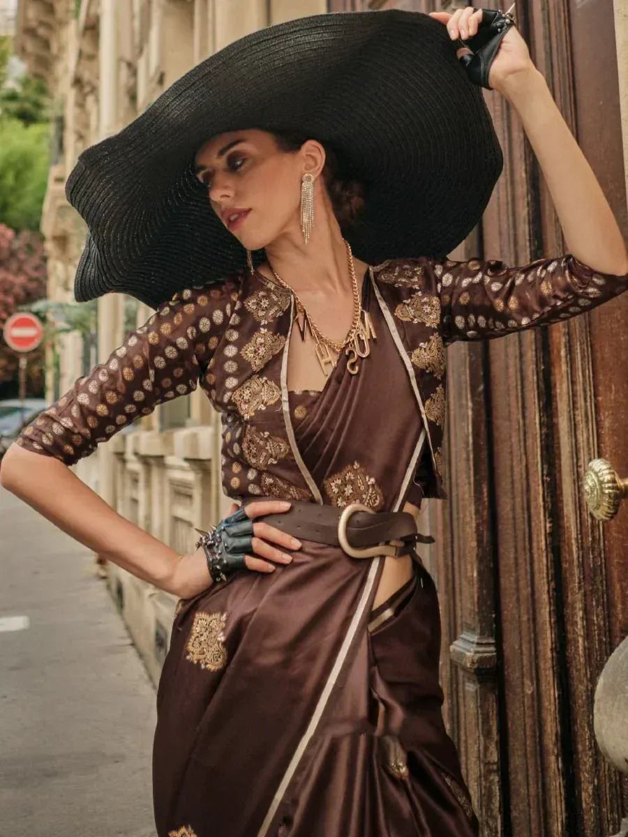 Brown embroidered saree with gold motifs, styled with wide-brim hat and statement jewelry for ethnic fashion