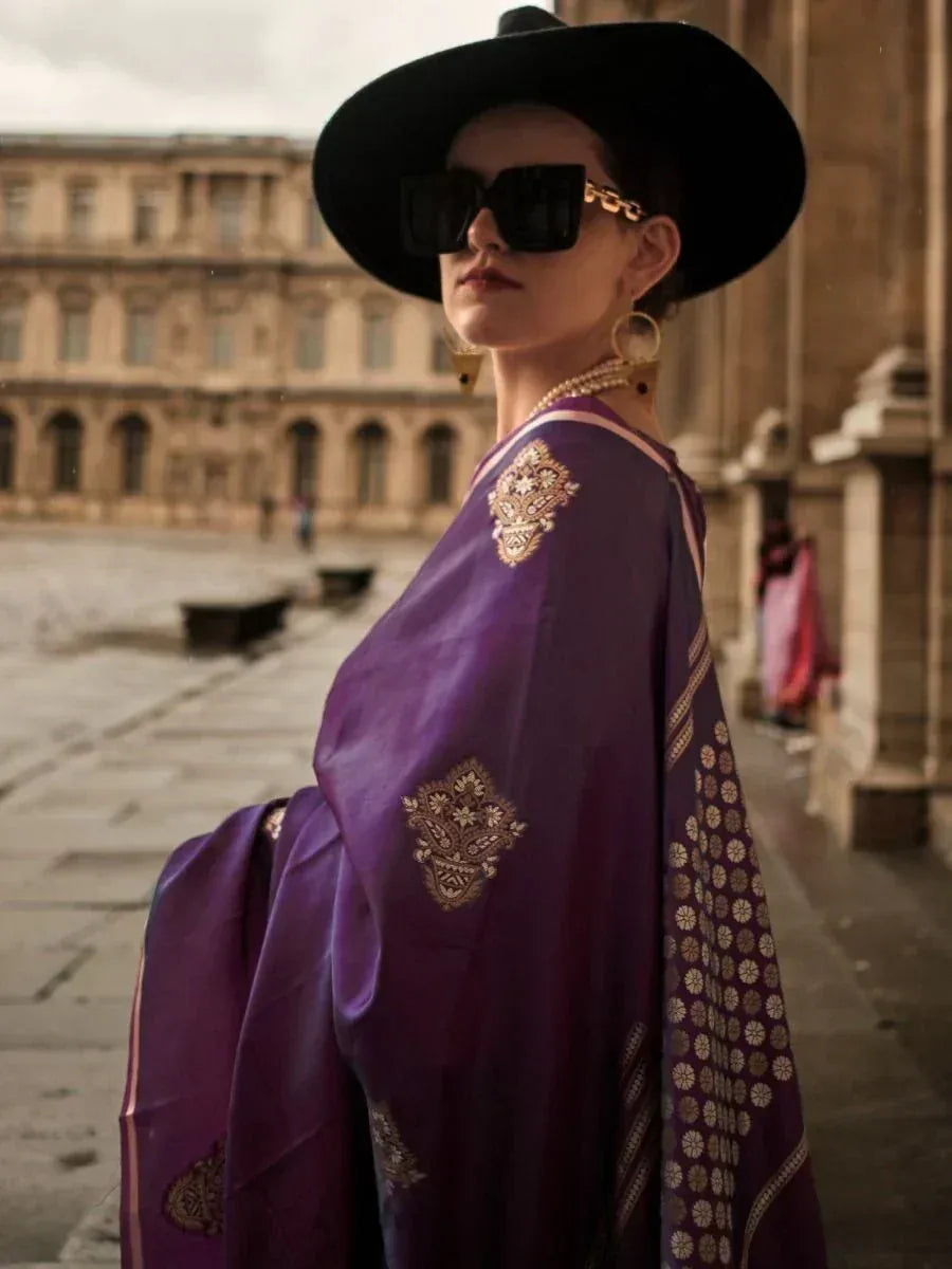 Purple embroidered ethnic gown with gold detailing, styled with black hat and sunglasses for modern Indian fashion