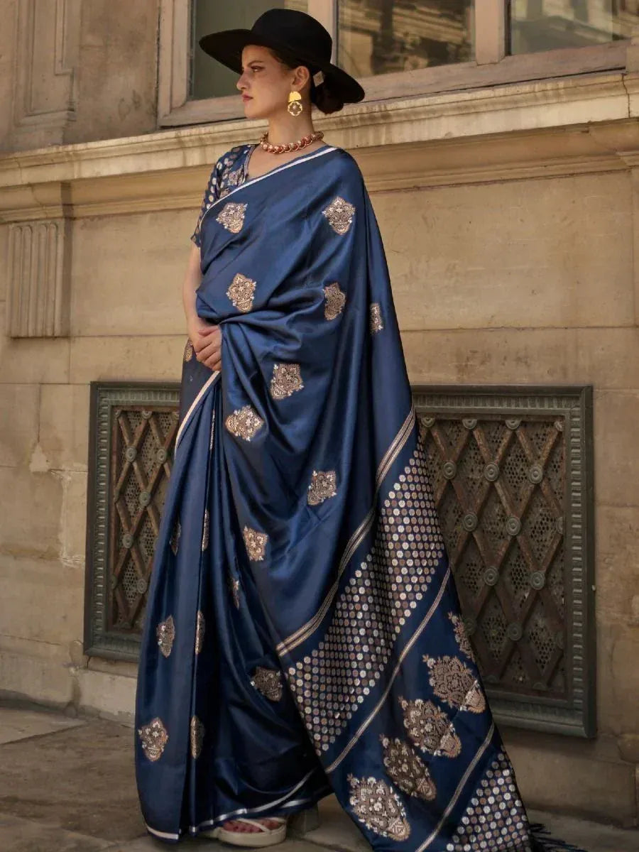 Navy blue designer saree with gold embroidery, styled with black hat and statement jewelry for ethnic wear