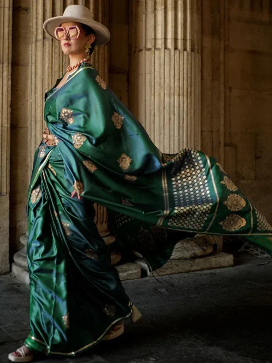 Elegant green silk saree with gold embroidery, styled with hat and sunglasses for modern ethnic look