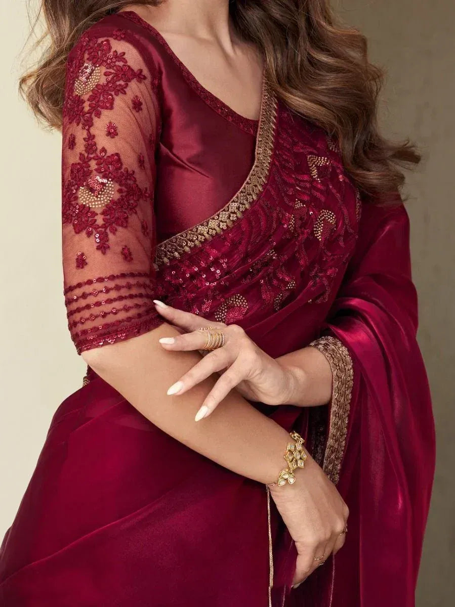 Maroon designer saree with floral embroidery and gold sequin border, paired with sheer sleeve blouse