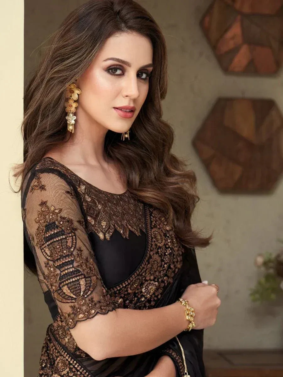 Elegant black saree with gold embroidery and sheer sleeves, perfect for Indian ethnic wear occasions.